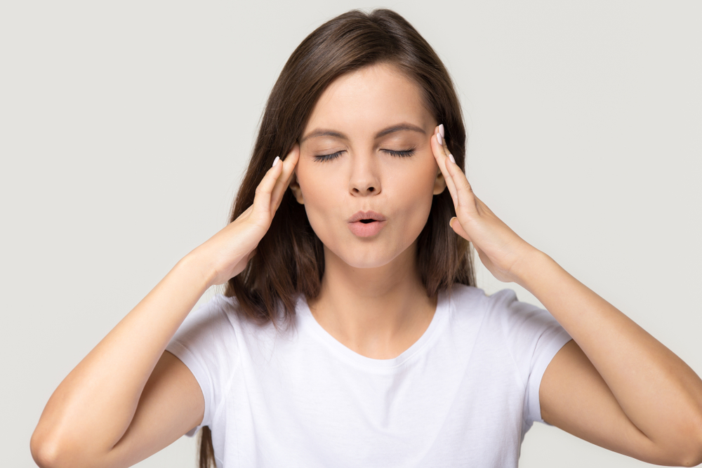 Une femme soulage sa douleur grâce à la réflexologie auriculaire au laser